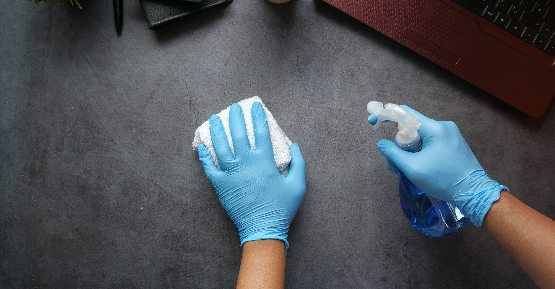 Disinfecting a desk during an office clean